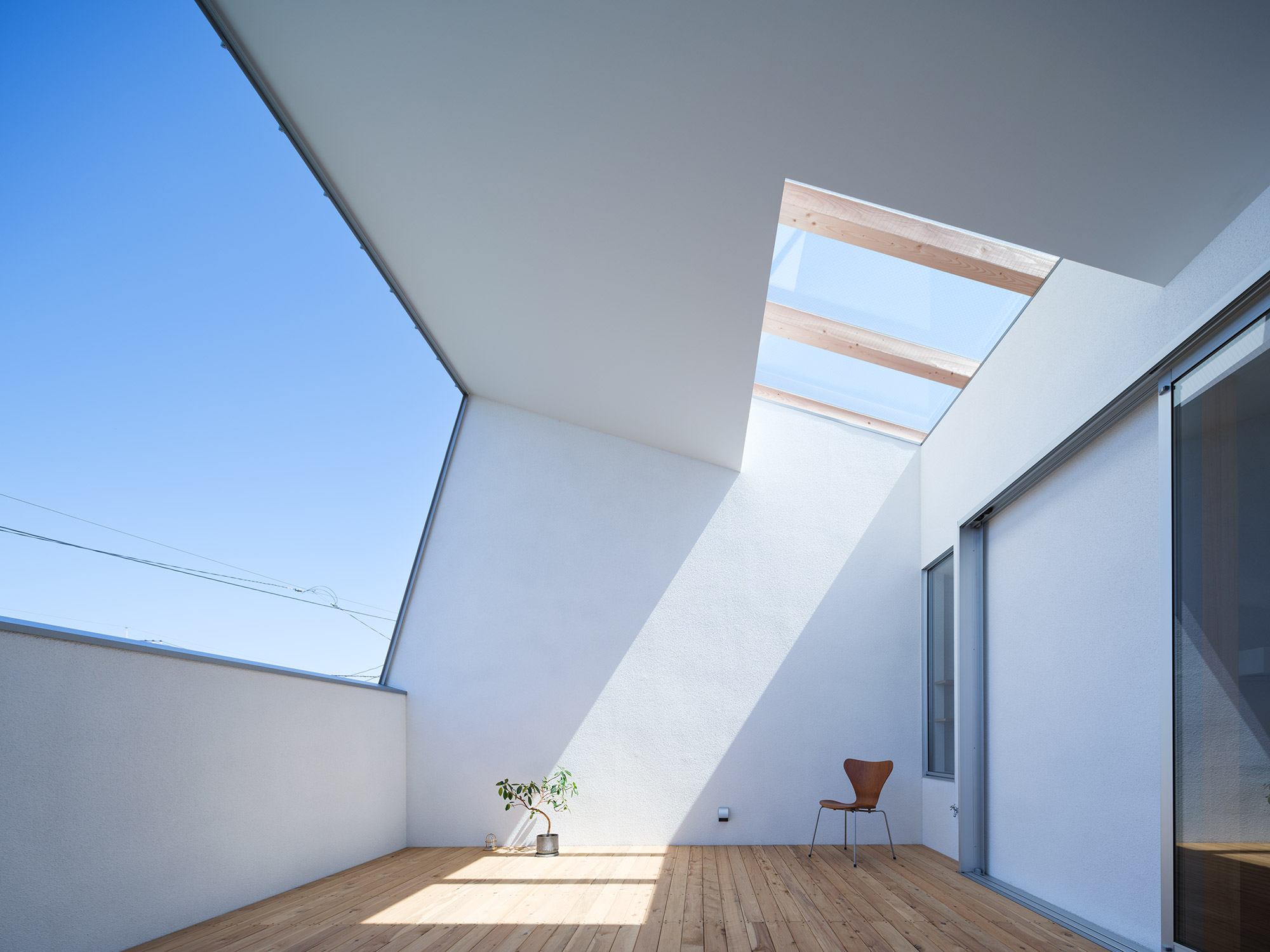Rooftop terrace with an angled ceiling under a blue sky