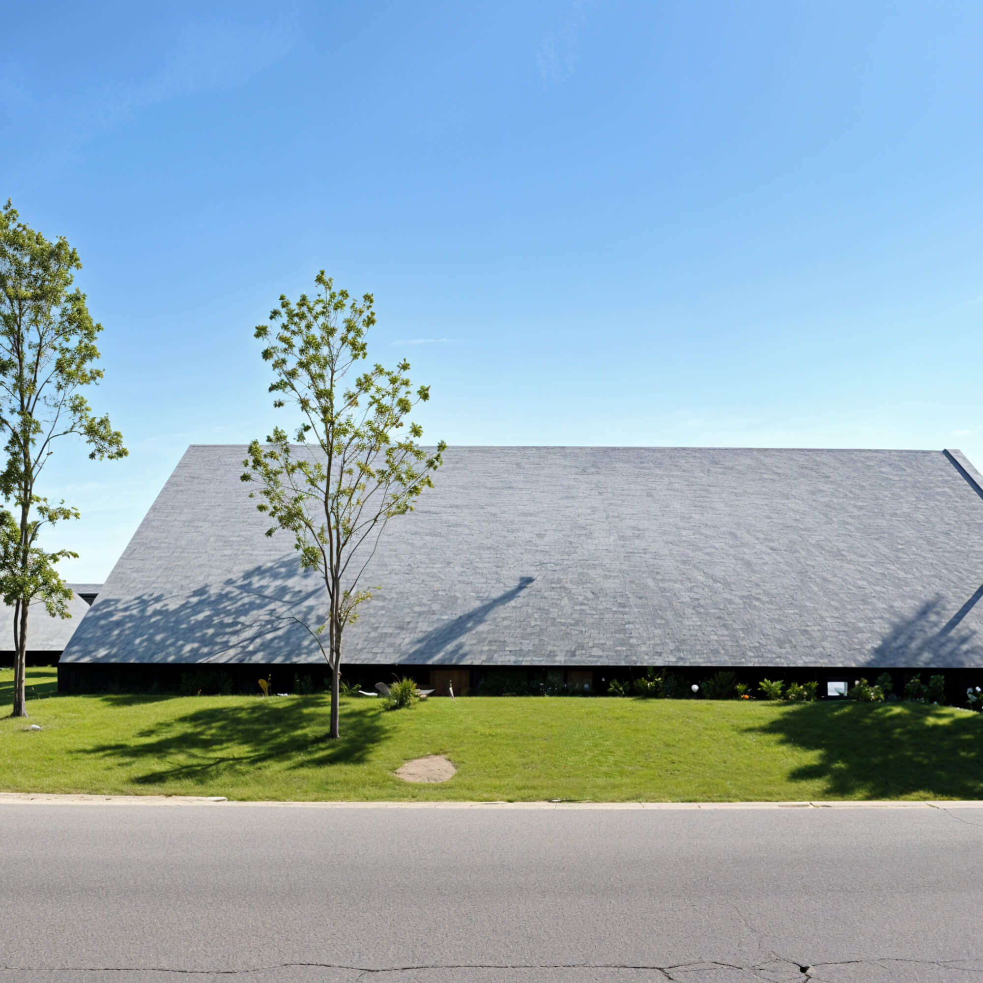 Facade featuring a lawn and large gabled roof