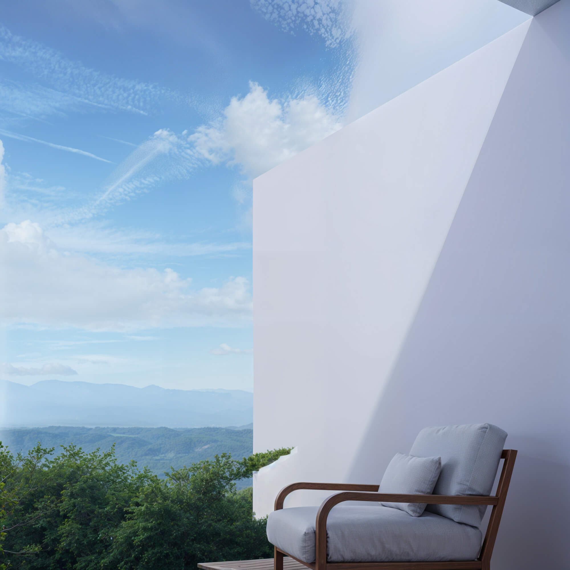 Outdoor space with a white wall and chairs set against a backdrop of mountains